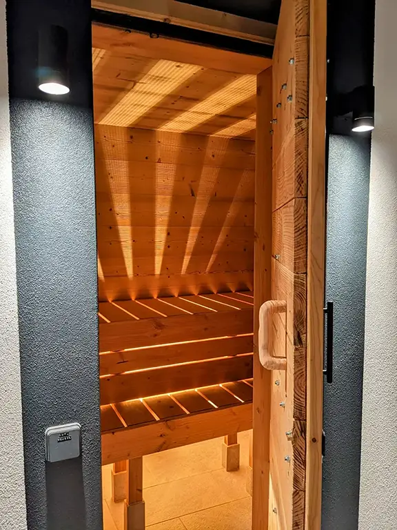 porte d'entrée du sauna ouverte donnant un aperçu de ce qui nous attend